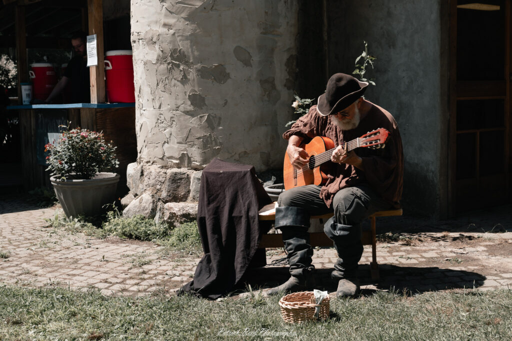 A costumed performer at the Michigan Renaissance Festival 2025, wearing traditional Renaissance attire during a live event in Holly, Michigan.