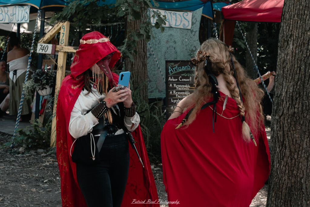 A costumed performer at the Michigan Renaissance Festival 2025, wearing traditional Renaissance attire during a live event in Holly, Michigan.