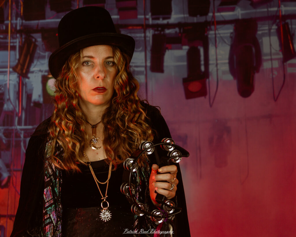 A woman dressed in flowing bohemian attire, channeling Stevie Nicks with layered fabrics, soft textures, and moody lighting.