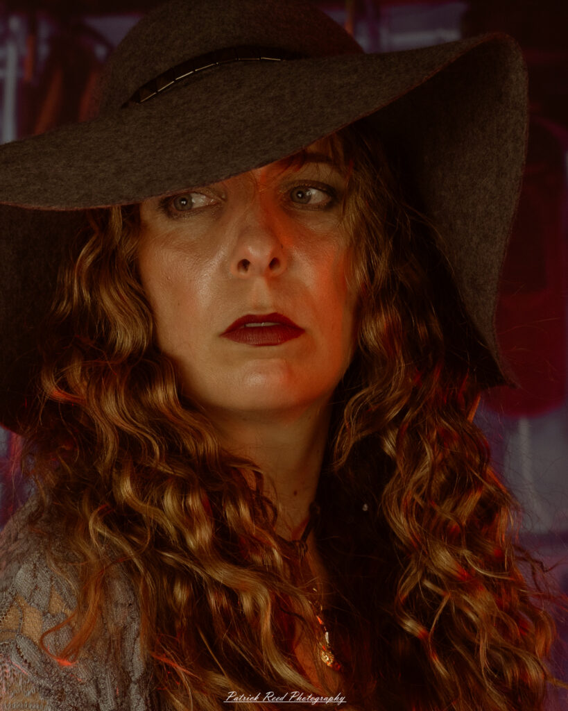 A woman dressed in flowing bohemian attire, channeling Stevie Nicks with layered fabrics, soft textures, and moody lighting.