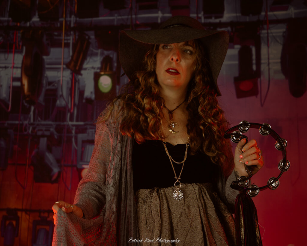 A woman dressed in flowing bohemian attire, channeling Stevie Nicks with layered fabrics, soft textures, and moody lighting.