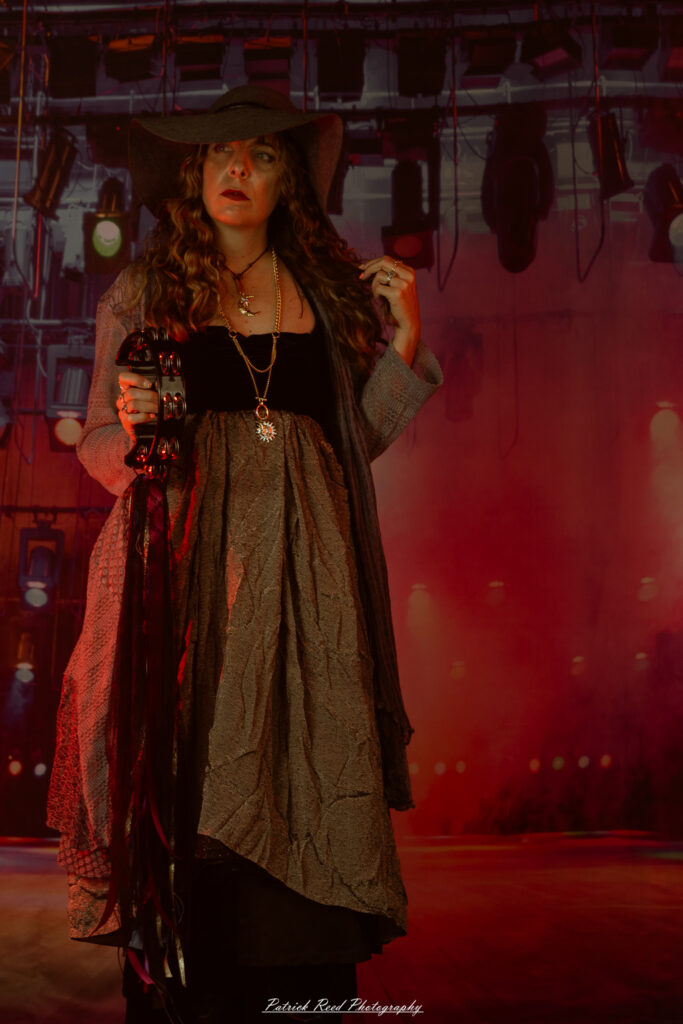 A woman dressed in flowing bohemian attire, channeling Stevie Nicks with layered fabrics, soft textures, and moody lighting.