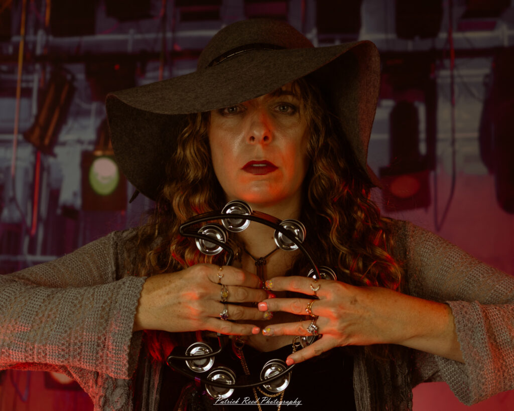 A woman dressed in flowing bohemian attire, channeling Stevie Nicks with layered fabrics, soft textures, and moody lighting.