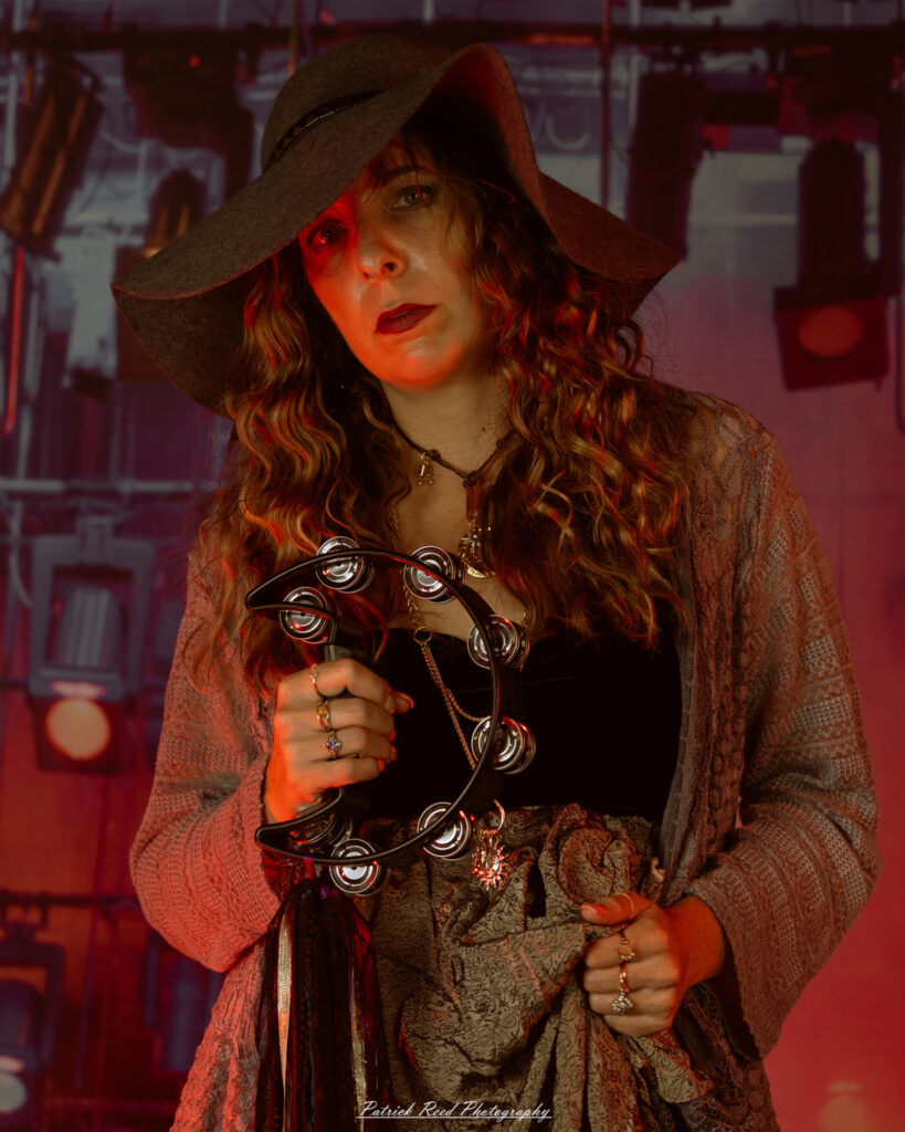 A woman dressed in flowing bohemian attire, channeling Stevie Nicks with layered fabrics, soft textures, and moody lighting.