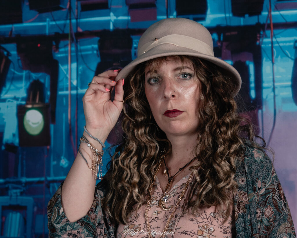 A woman dressed in flowing bohemian attire, channeling Stevie Nicks with layered fabrics, soft textures, and moody lighting.