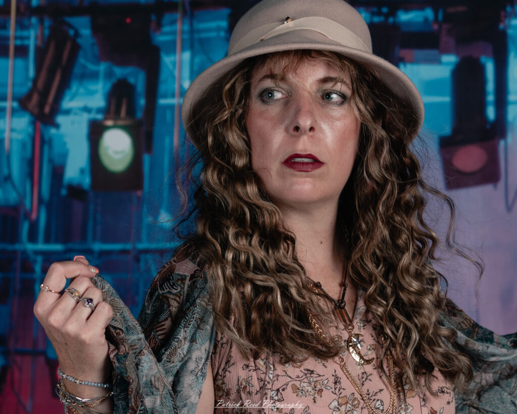 A woman dressed in flowing bohemian attire, channeling Stevie Nicks with layered fabrics, soft textures, and moody lighting.
