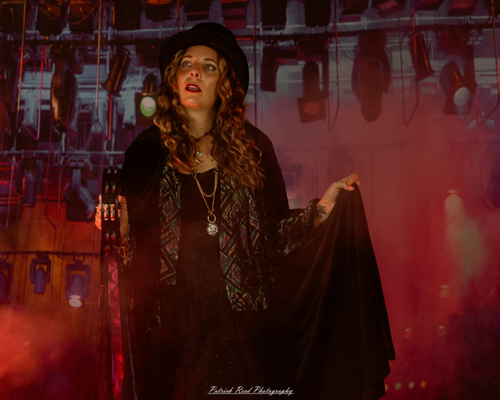 A woman dressed in flowing bohemian attire, channeling Stevie Nicks with layered fabrics, soft textures, and moody lighting.
