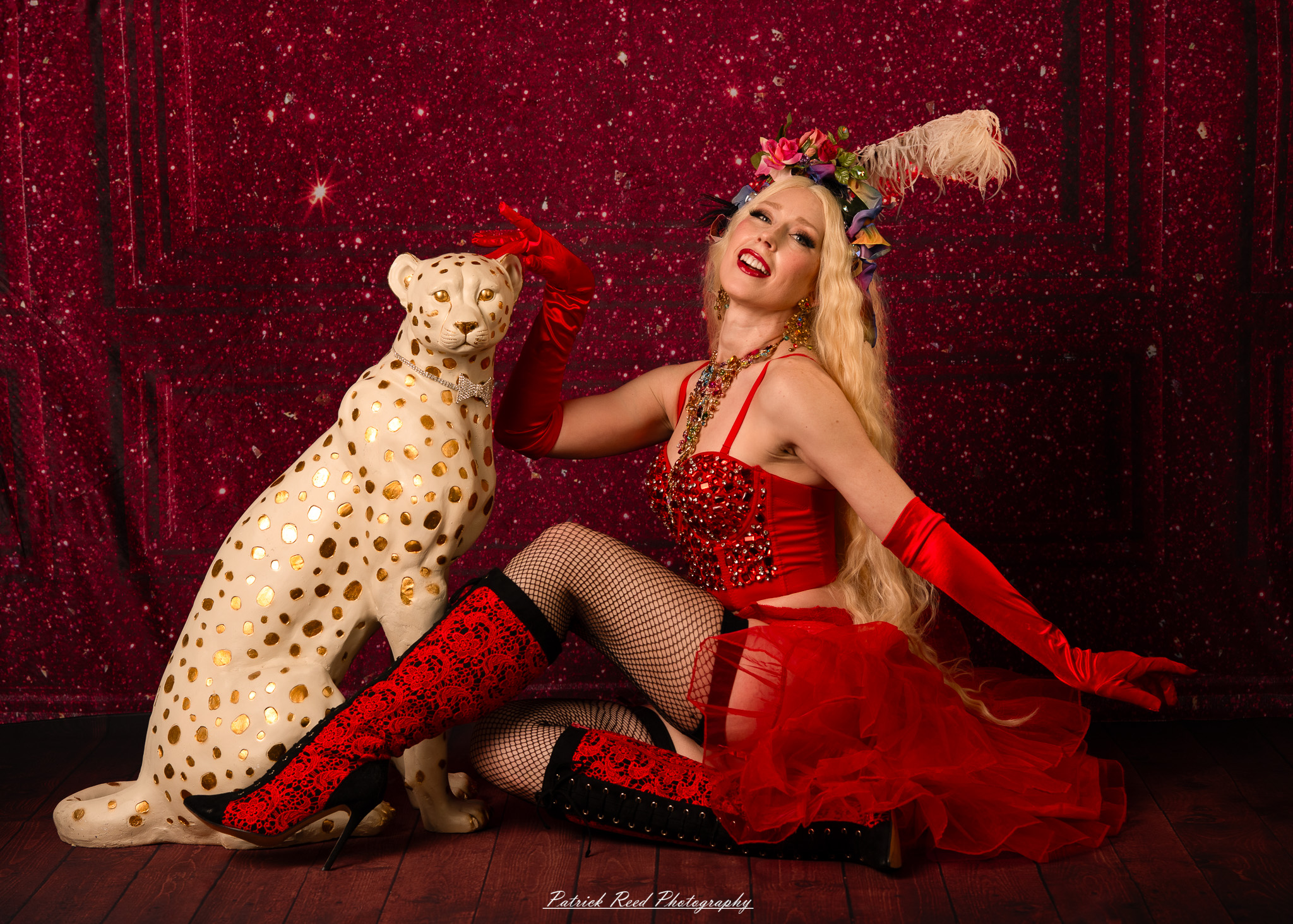 A cabaret-themed portrait featuring dramatic stage-inspired lighting, bold styling, and theatrical atmosphere. The image captures vintage glamour with a moody, performance-driven aesthetic.