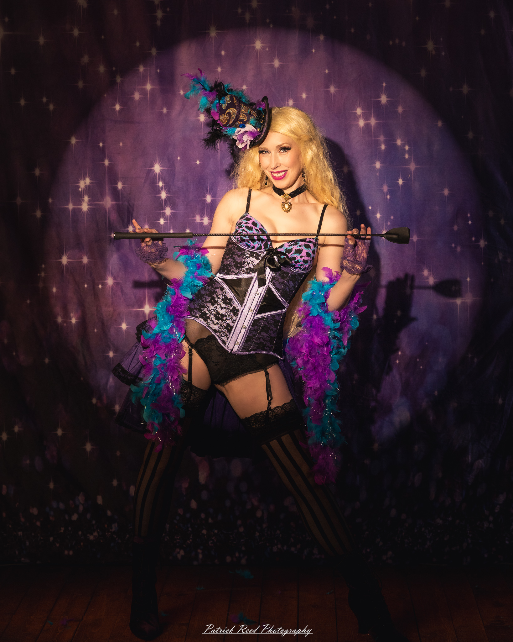 A cabaret-themed portrait featuring dramatic stage-inspired lighting, bold styling, and theatrical atmosphere. The image captures vintage glamour with a moody, performance-driven aesthetic.