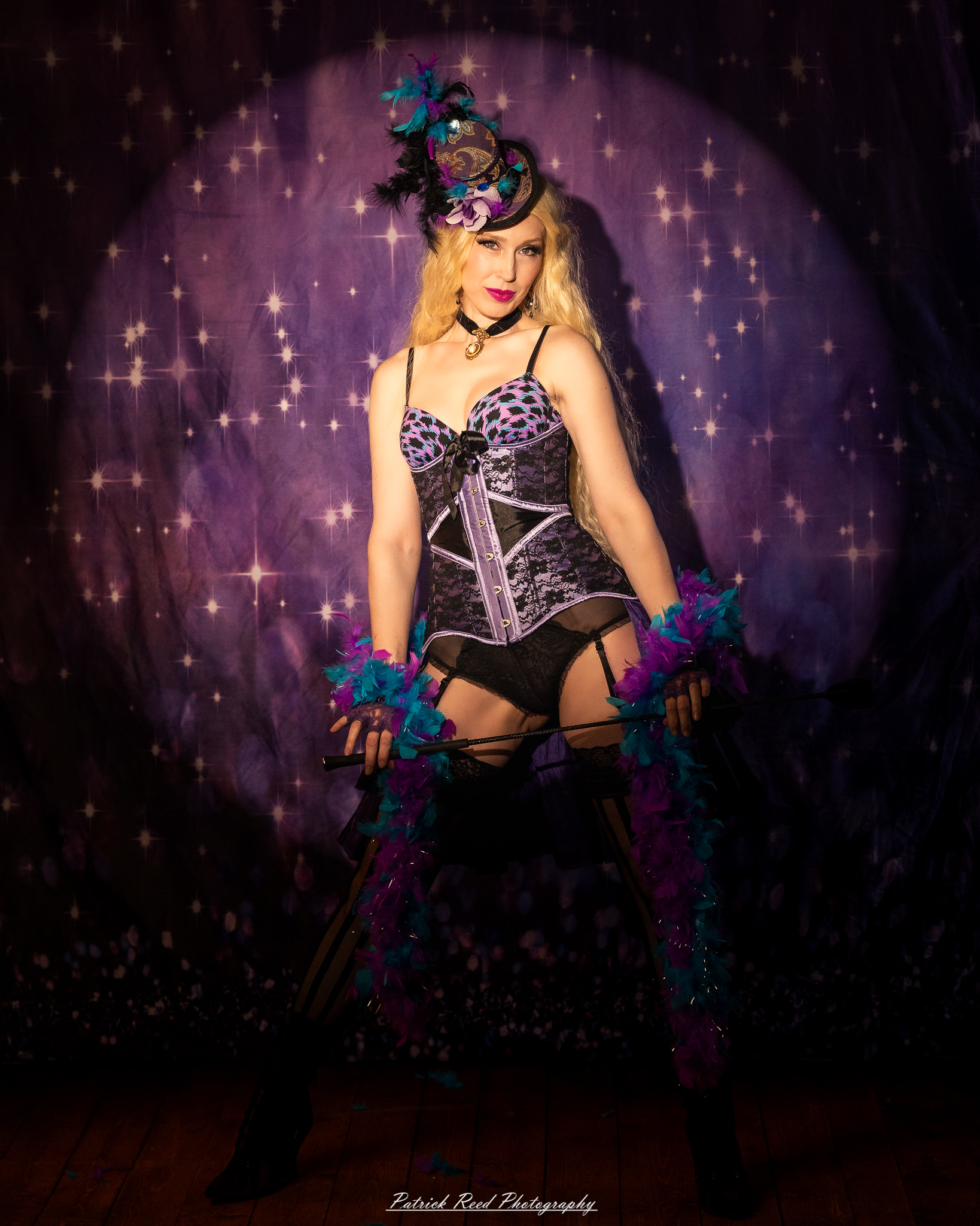 A cabaret-themed portrait featuring dramatic stage-inspired lighting, bold styling, and theatrical atmosphere. The image captures vintage glamour with a moody, performance-driven aesthetic.