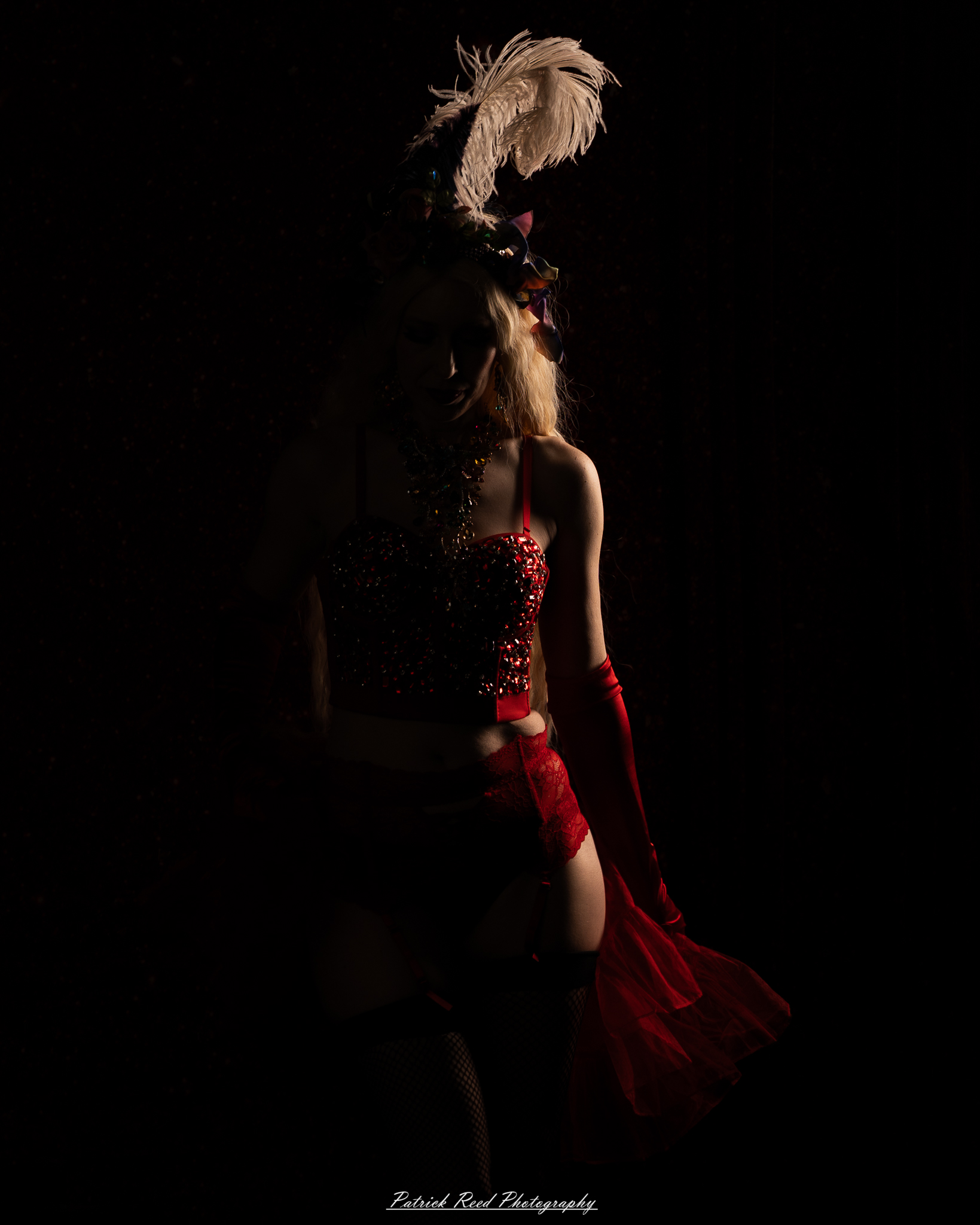 A cabaret-themed portrait featuring dramatic stage-inspired lighting, bold styling, and theatrical atmosphere. The image captures vintage glamour with a moody, performance-driven aesthetic.