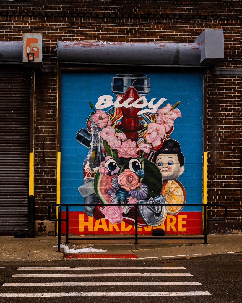 Large-scale mural in Eastern Market Detroit with layered graffiti textures and urban street art composition.