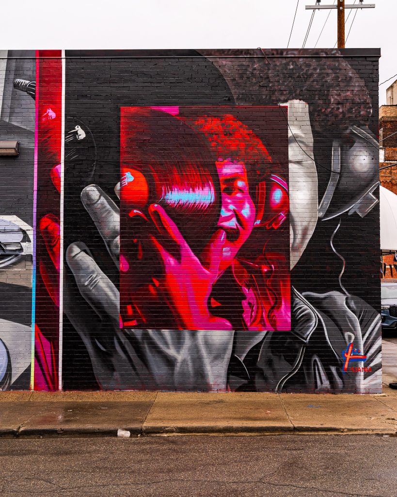 Large-scale mural in Eastern Market Detroit with layered graffiti textures and urban street art composition.