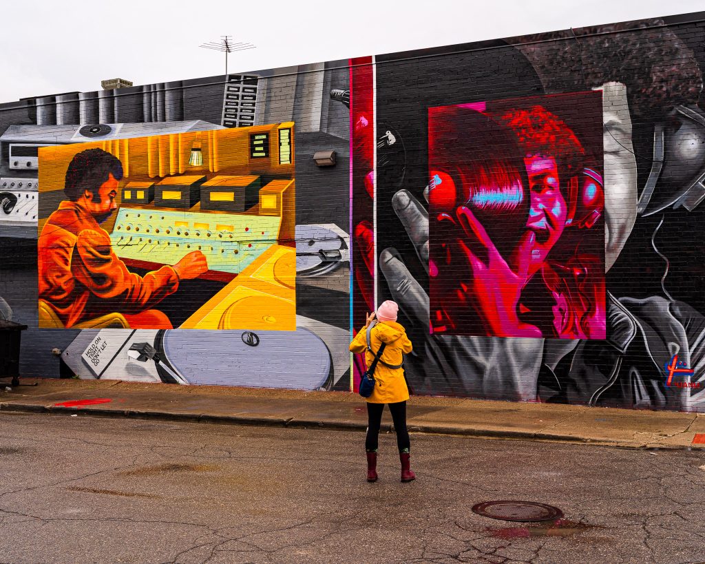 Large-scale mural in Eastern Market Detroit with layered graffiti textures and urban street art composition.