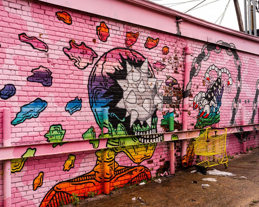 Large-scale mural in Eastern Market Detroit with layered graffiti textures and urban street art composition.