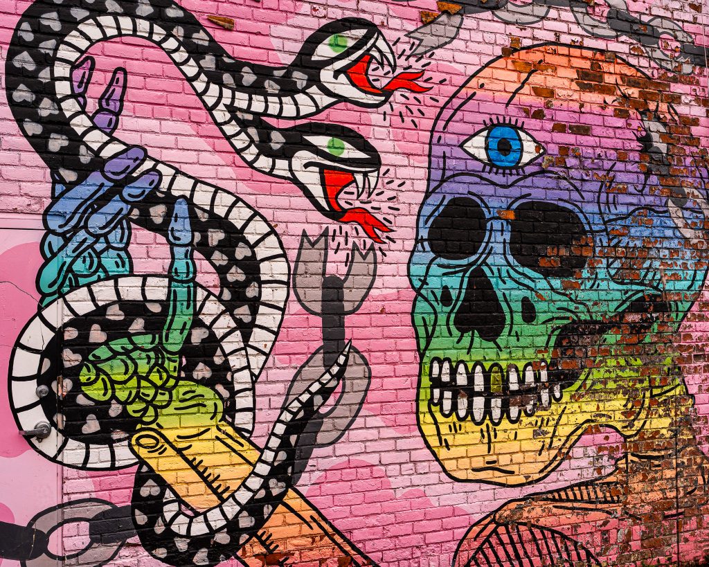 Large-scale mural in Eastern Market Detroit with layered graffiti textures and urban street art composition.