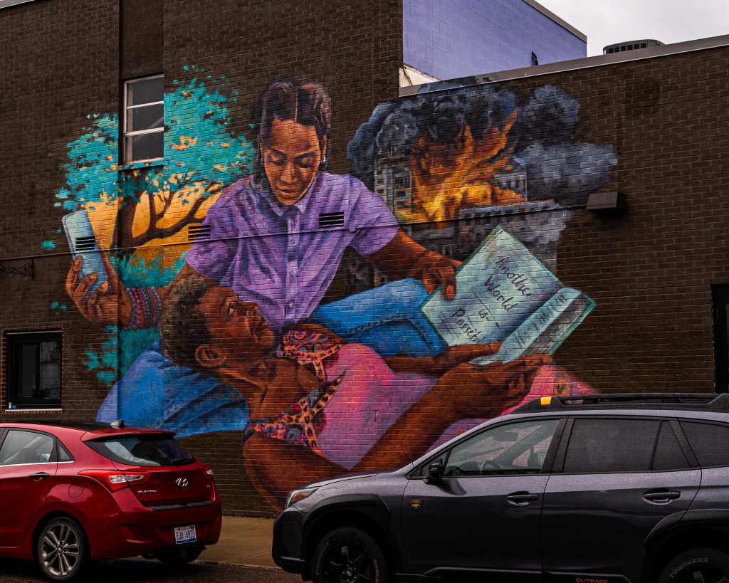 Large-scale mural in Eastern Market Detroit with layered graffiti textures and urban street art composition.