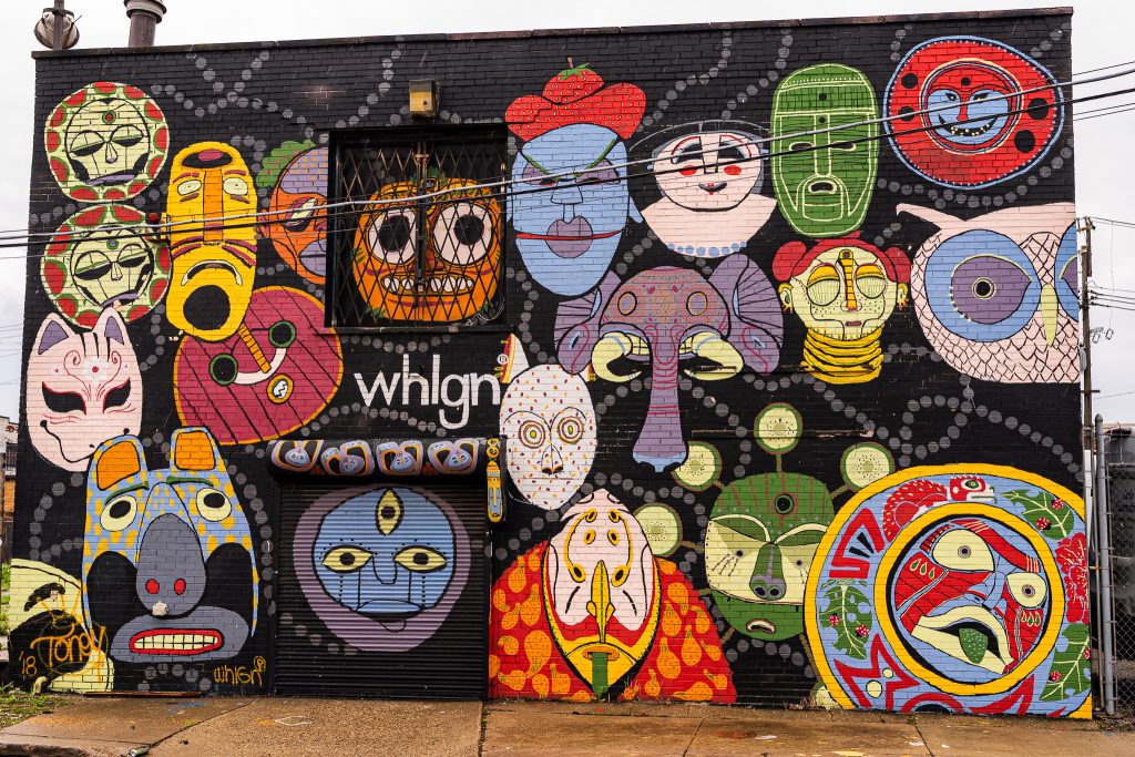 Large-scale mural in Eastern Market Detroit with layered graffiti textures and urban street art composition.