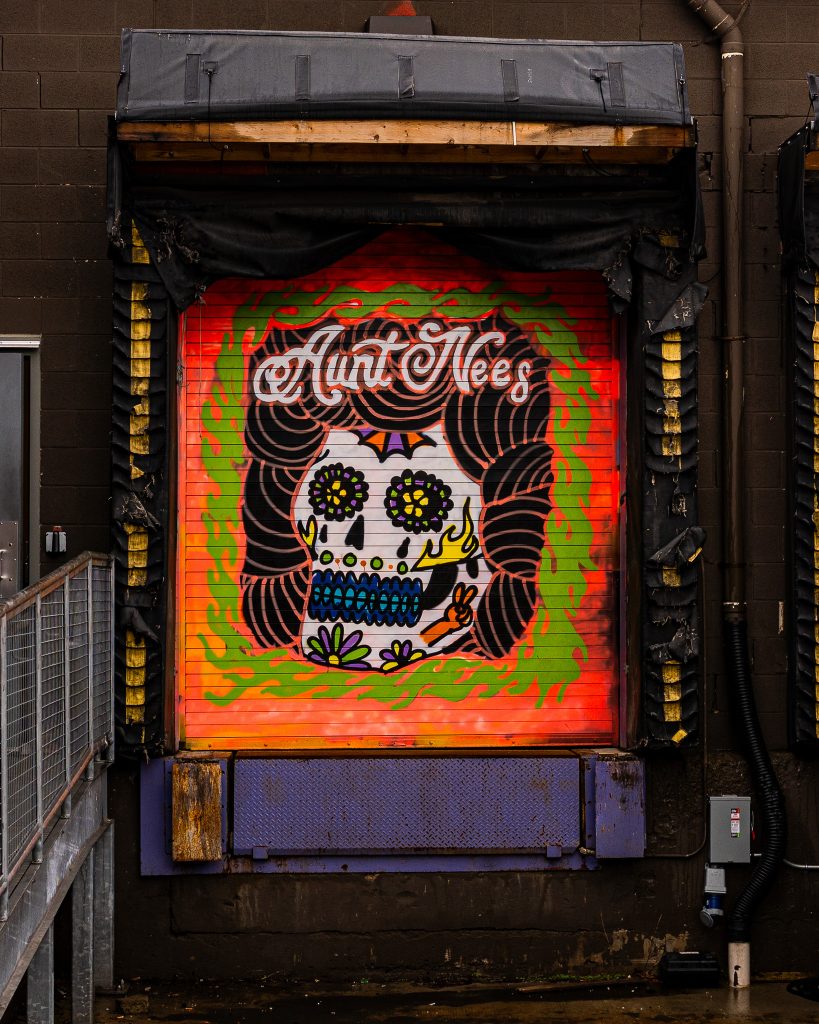 Large-scale mural in Eastern Market Detroit with layered graffiti textures and urban street art composition.