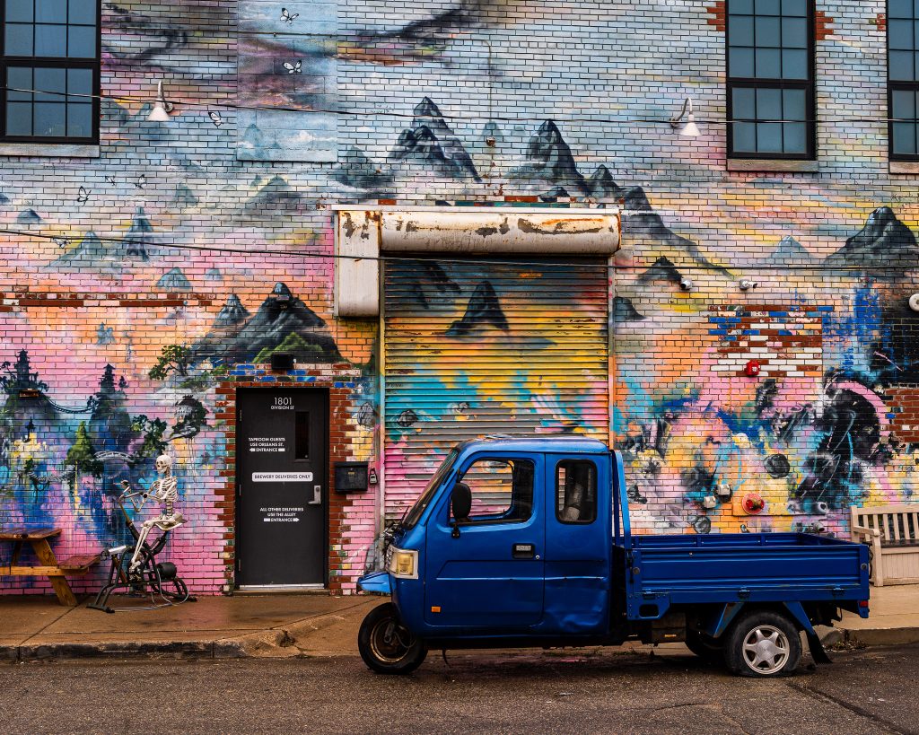 Large-scale mural in Eastern Market Detroit with layered graffiti textures and urban street art composition.