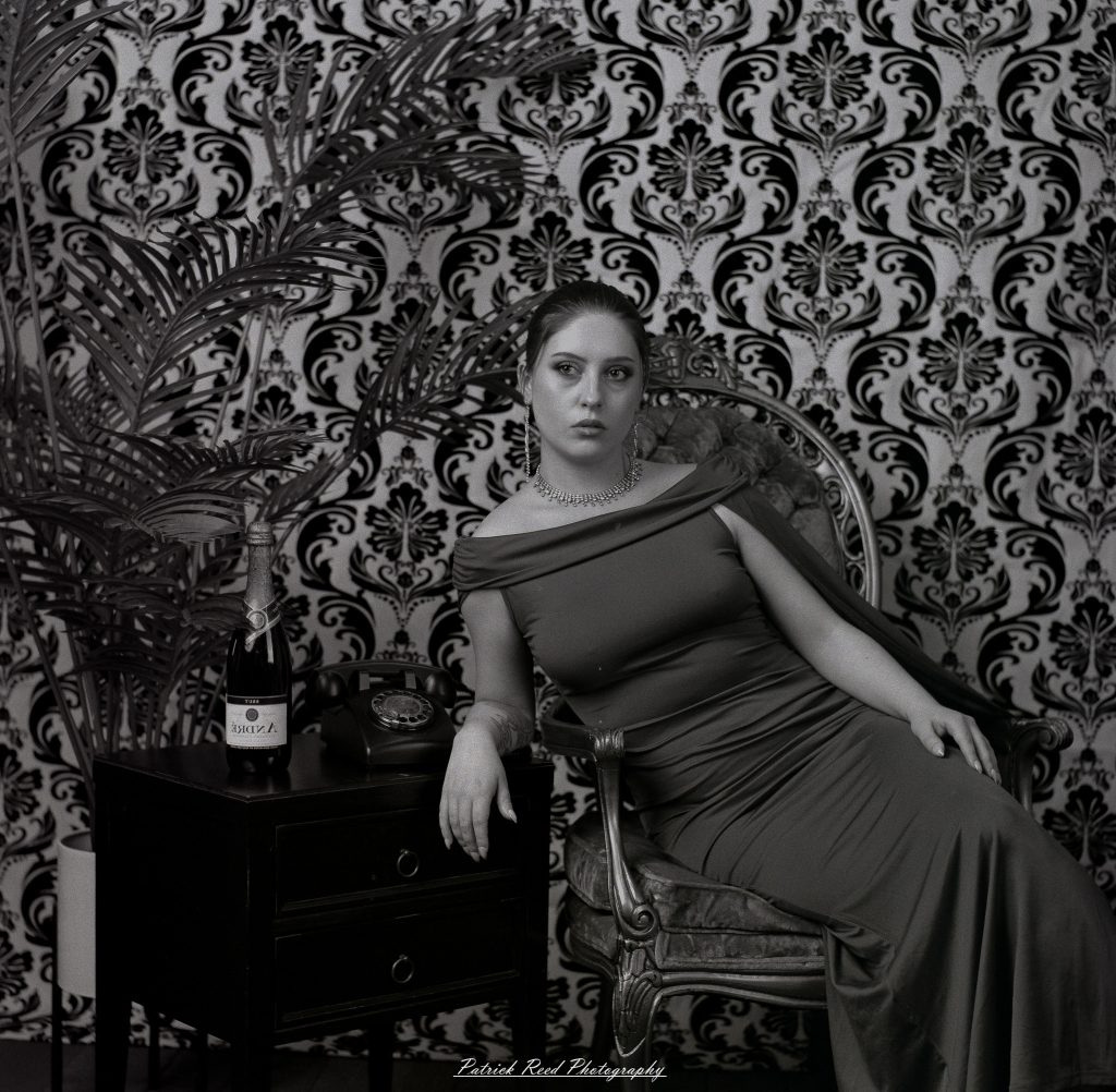 A vintage fashion portrait of Jinx, photographed on medium format film using a Mamiya C33. The session combines classic styling with the tonal depth and softness of analog photography, creating a timeless studio portrait inspired by mid-century fashion aesthetics.