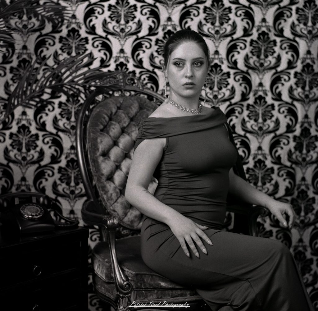 A vintage fashion portrait of Jinx, photographed on medium format film using a Mamiya C33. The session combines classic styling with the tonal depth and softness of analog photography, creating a timeless studio portrait inspired by mid-century fashion aesthetics.