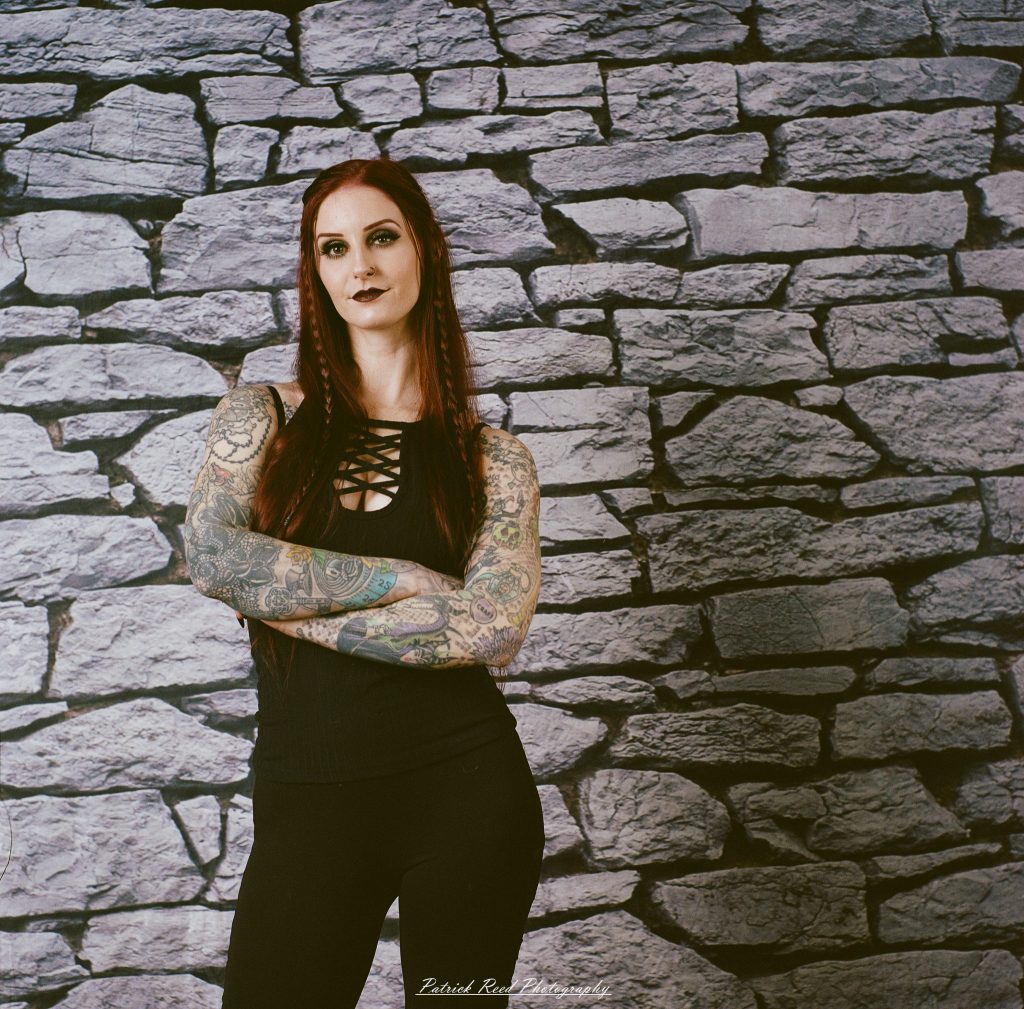 A medium format film portrait of a model styled in a casual goth look, photographed using a Mamiya C33 camera with moody studio lighting and classic analog texture.