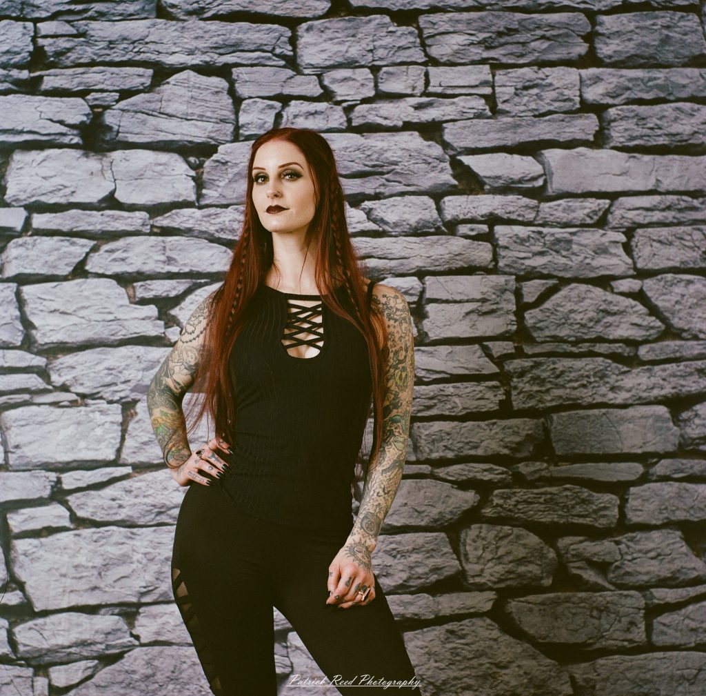 A medium format film portrait of a model styled in a casual goth look, photographed using a Mamiya C33 camera with moody studio lighting and classic analog texture.
