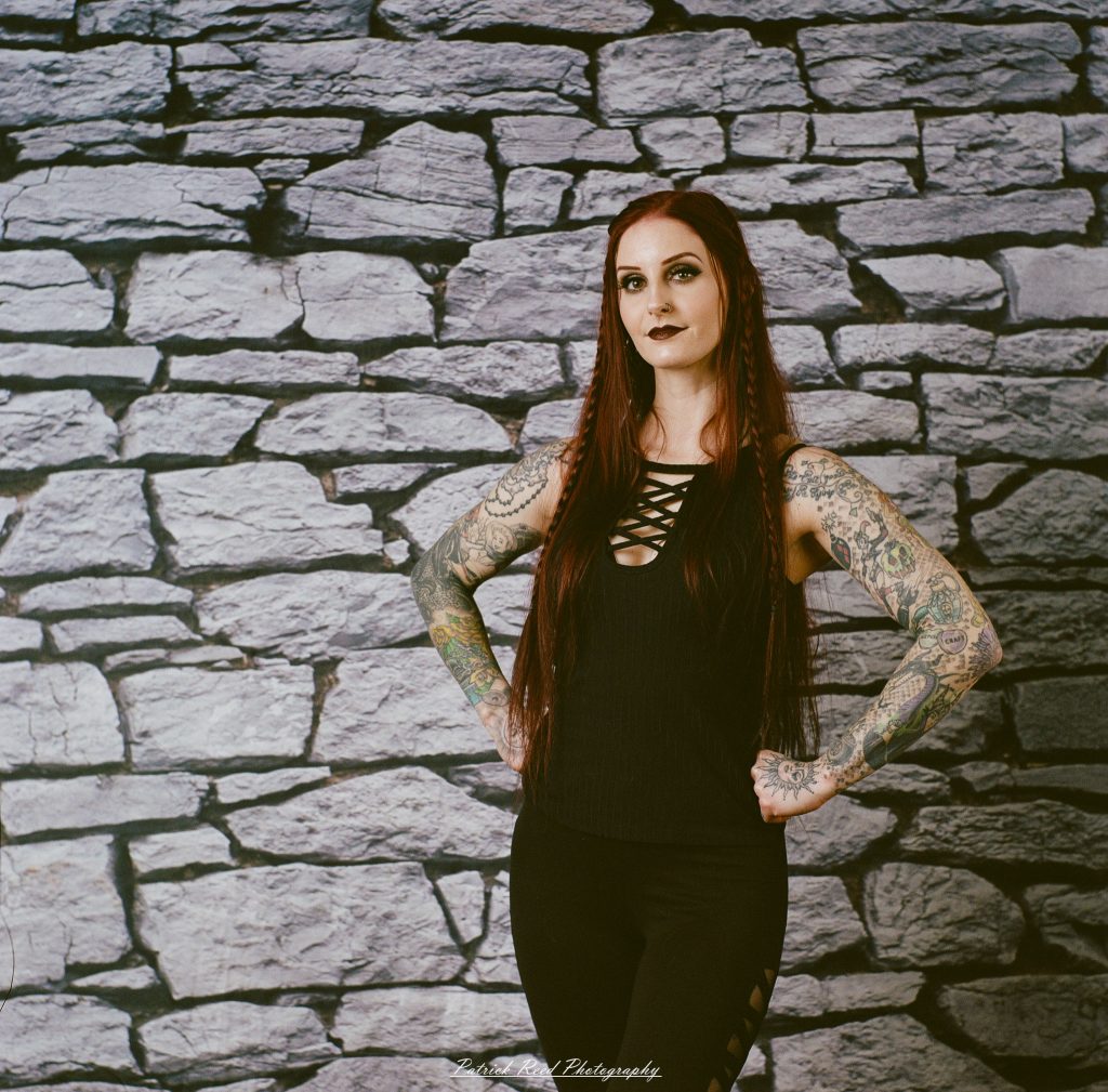A medium format film portrait of a model styled in a casual goth look, photographed using a Mamiya C33 camera with moody studio lighting and classic analog texture.