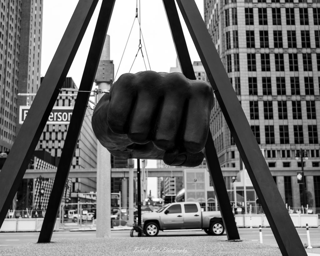 Black and white street photography in downtown Detroit, Michigan capturing urban architecture, city life, public art, and Detroit riverfront scenes in a documentary photography style.