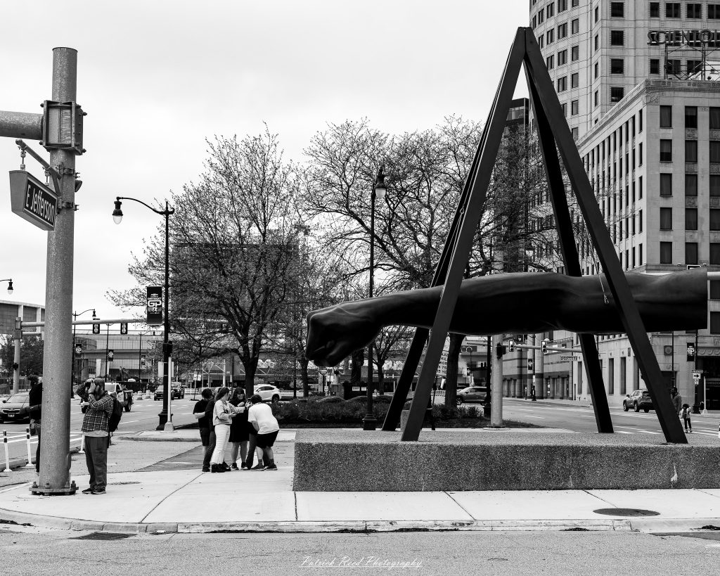 Black and white street photography in downtown Detroit, Michigan capturing urban architecture, city life, public art, and Detroit riverfront scenes in a documentary photography style.