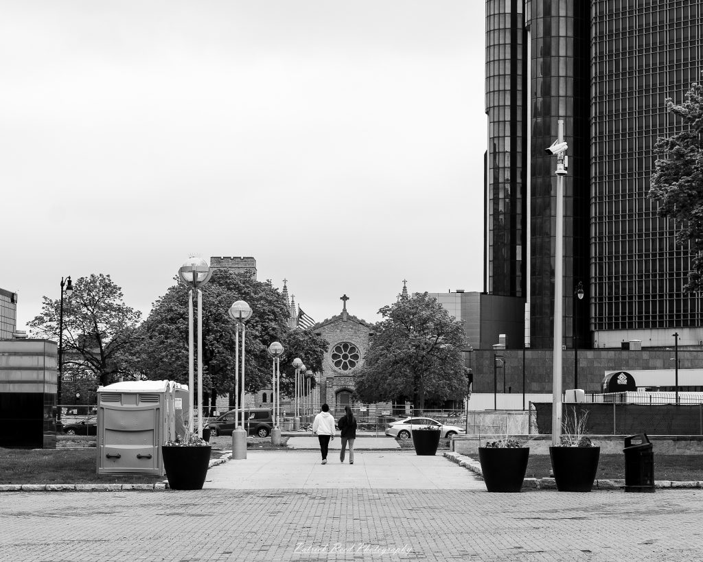 Black and white street photography in downtown Detroit, Michigan capturing urban architecture, city life, public art, and Detroit riverfront scenes in a documentary photography style.