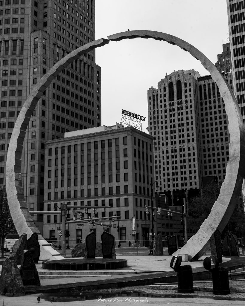 Black and white street photography in downtown Detroit, Michigan capturing urban architecture, city life, public art, and Detroit riverfront scenes in a documentary photography style.
