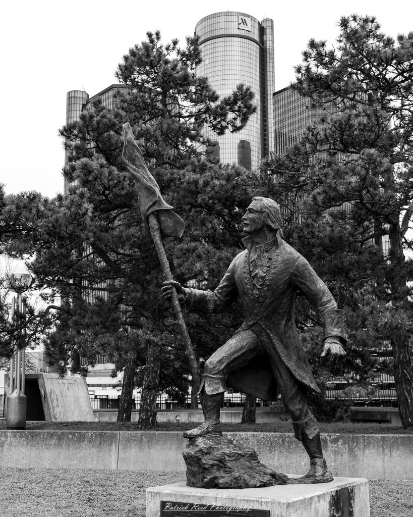 Black and white street photography in downtown Detroit, Michigan capturing urban architecture, city life, public art, and Detroit riverfront scenes in a documentary photography style.