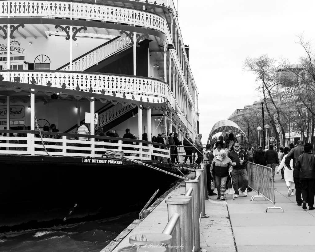 Black and white street photography in downtown Detroit, Michigan capturing urban architecture, city life, public art, and Detroit riverfront scenes in a documentary photography style.