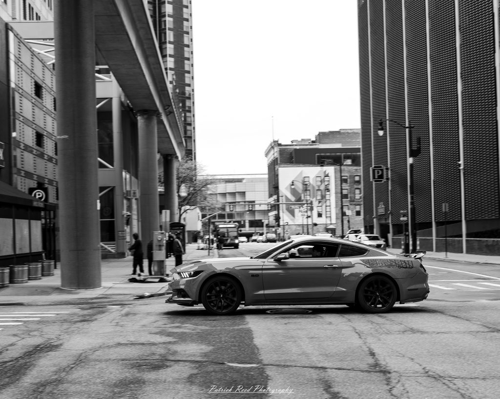 Black and white street photography in downtown Detroit, Michigan capturing urban architecture, city life, public art, and Detroit riverfront scenes in a documentary photography style.