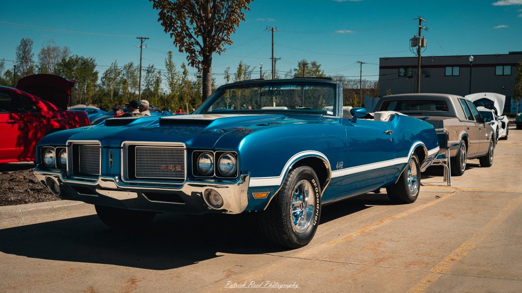 Classic car photography from a Michigan car show featuring vintage muscle cars, hot rods, classic trucks, and automotive detail shots captured in a cinematic documentary style.