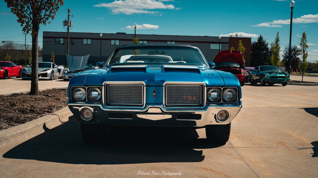Classic car photography from a Michigan car show featuring vintage muscle cars, hot rods, classic trucks, and automotive detail shots captured in a cinematic documentary style.