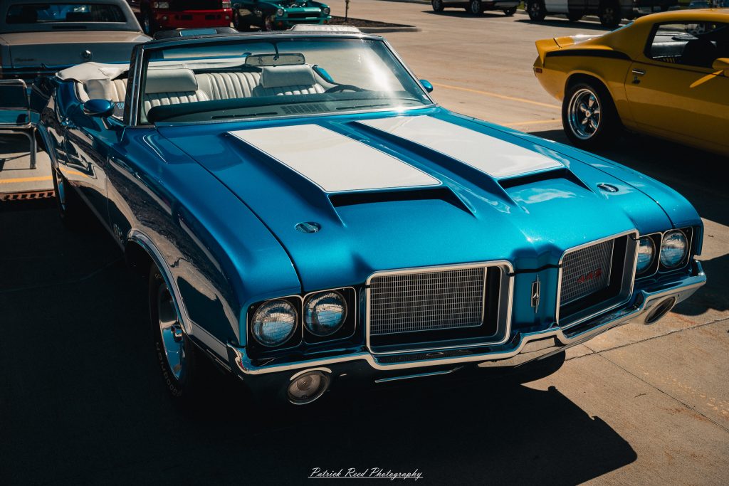 Classic car photography from a Michigan car show featuring vintage muscle cars, hot rods, classic trucks, and automotive detail shots captured in a cinematic documentary style.