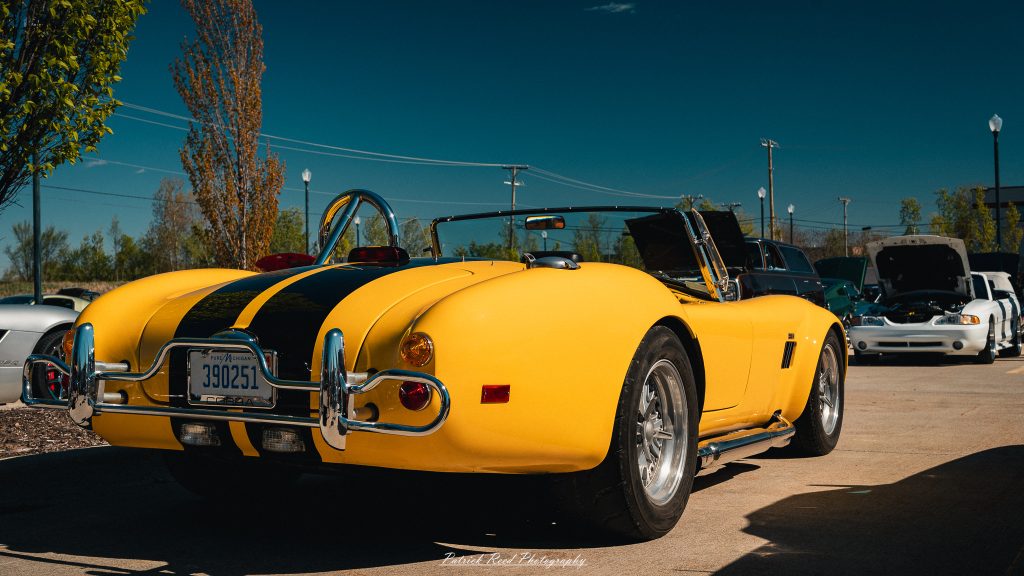 Classic car photography from a Michigan car show featuring vintage muscle cars, hot rods, classic trucks, and automotive detail shots captured in a cinematic documentary style.