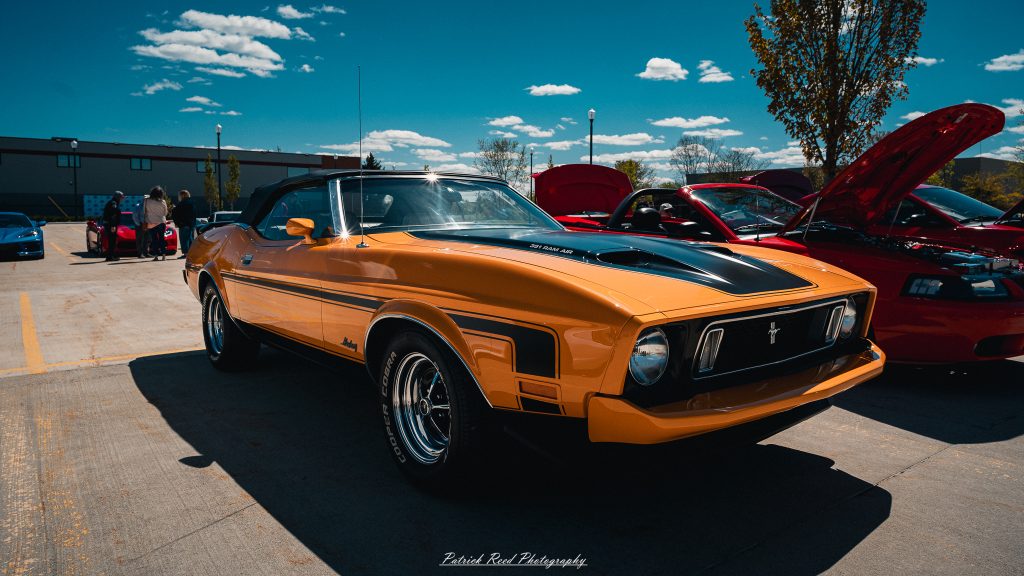 Classic car photography from a Michigan car show featuring vintage muscle cars, hot rods, classic trucks, and automotive detail shots captured in a cinematic documentary style.