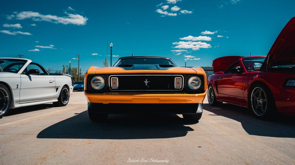 Classic car photography from a Michigan car show featuring vintage muscle cars, hot rods, classic trucks, and automotive detail shots captured in a cinematic documentary style.