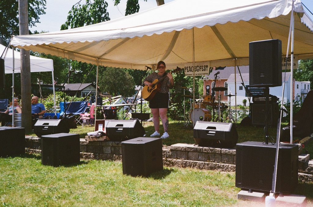 Street photography captured on a Rollei 35S at Peacefest in Waterford, Michigan, featuring festival attendees, live entertainment, community activities, and candid moments documented on 35mm film.