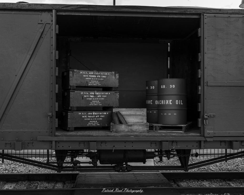 Black-and-white documentary photographs from the Steam Railroading Institute in Ohio, featuring historic steam locomotives, vintage passenger railcars, railroad machinery, restoration workshops, and industrial details preserving America's railroad heritage.