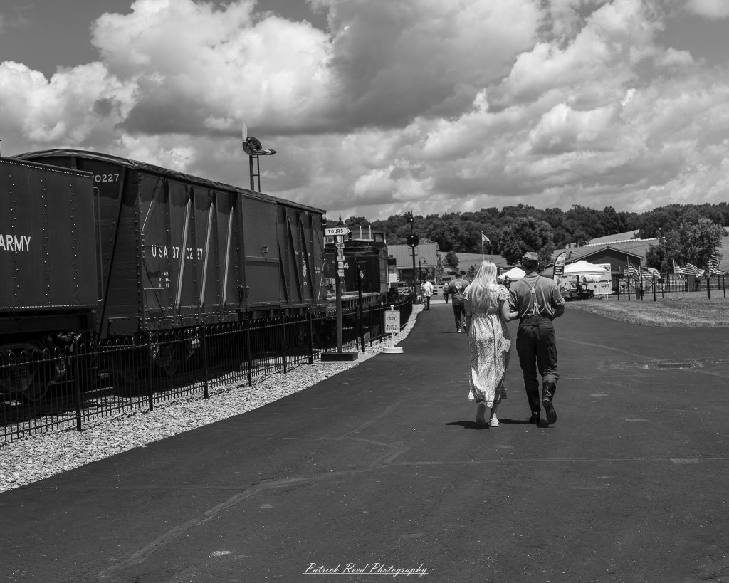 Black-and-white documentary photographs from the Steam Railroading Institute in Ohio, featuring historic steam locomotives, vintage passenger railcars, railroad machinery, restoration workshops, and industrial details preserving America's railroad heritage.