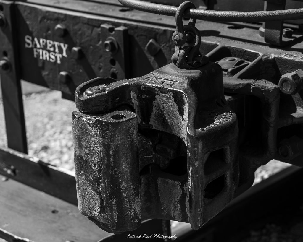 Black-and-white documentary photographs from the Steam Railroading Institute in Ohio, featuring historic steam locomotives, vintage passenger railcars, railroad machinery, restoration workshops, and industrial details preserving America's railroad heritage.