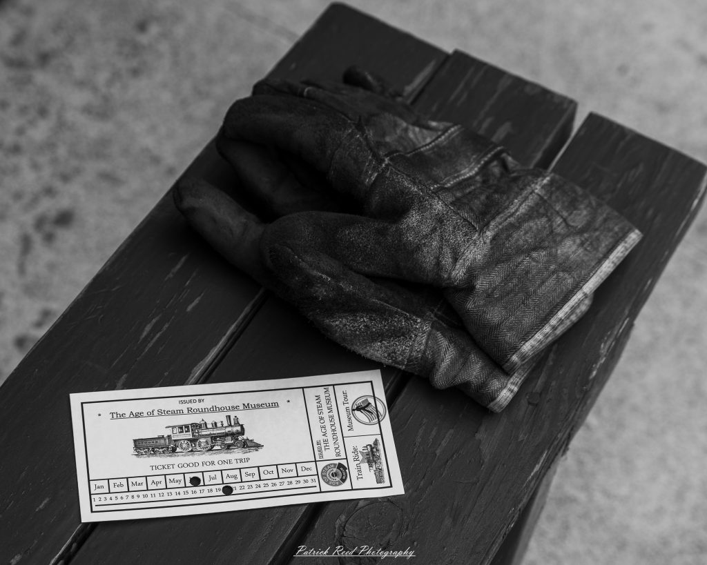 Black-and-white documentary photographs from the Steam Railroading Institute in Ohio, featuring historic steam locomotives, vintage passenger railcars, railroad machinery, restoration workshops, and industrial details preserving America's railroad heritage.