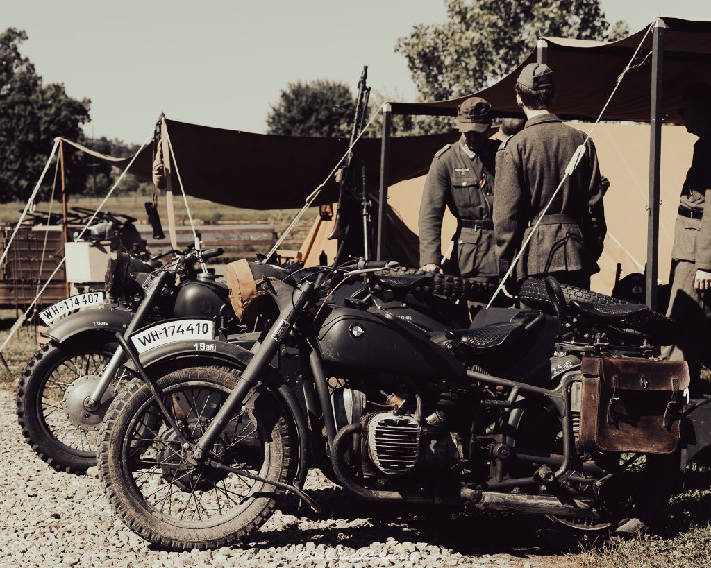 Documentary photographs of World War II reenactors at the Steam Railroading Institute, featuring authentic military uniforms, vintage trains, historical equipment, and living history demonstrations.