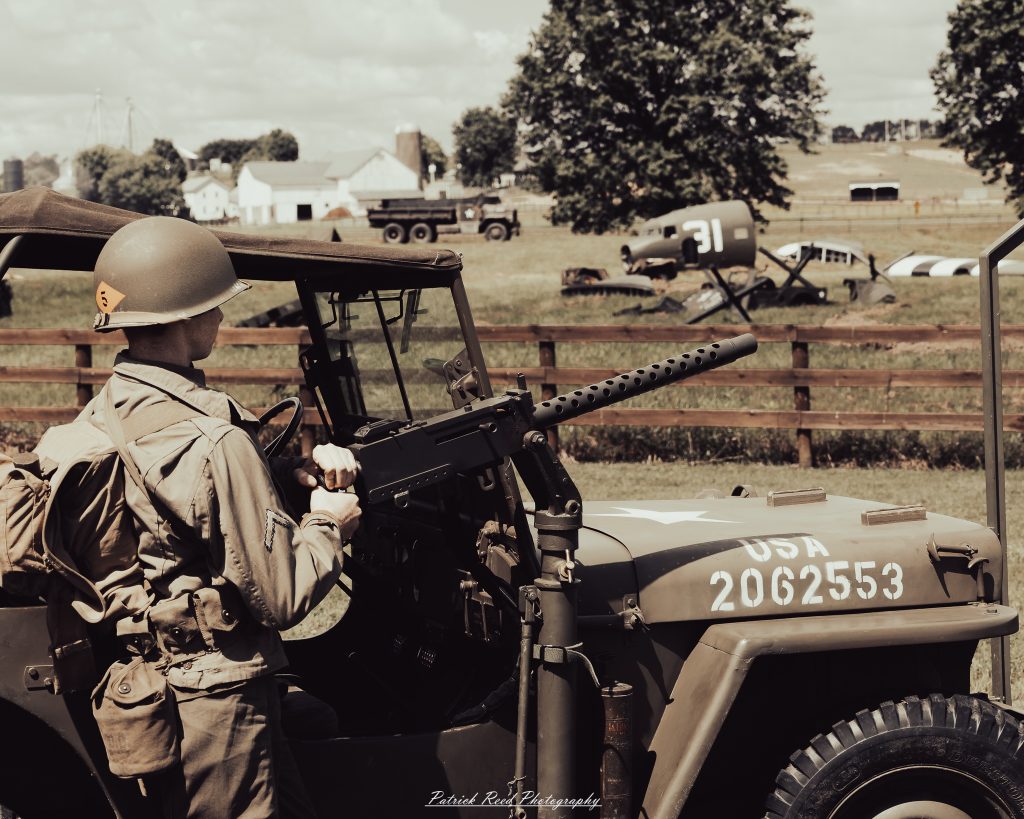 Documentary photographs of World War II reenactors at the Steam Railroading Institute, featuring authentic military uniforms, vintage trains, historical equipment, and living history demonstrations.
