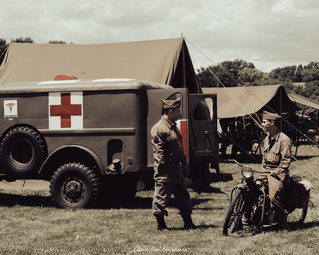 Documentary photographs of World War II reenactors at the Steam Railroading Institute, featuring authentic military uniforms, vintage trains, historical equipment, and living history demonstrations.